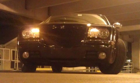 1999 Mercury Grand Marquis - Front view of a black Chrysler 300 sedan with its headlights illuminated.