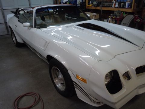 1980 Pontiac Trans Am - A white convertible with black racing stripes is parked in a garage.