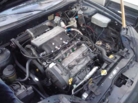2003 Hyundai Tiburon - The engine bay of a car, showing the engine, supercharger, and various hoses and components.