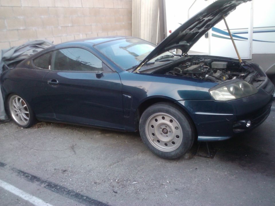 Dark blue 2003 Hyundai Tiburon with hood open, 3q-front view