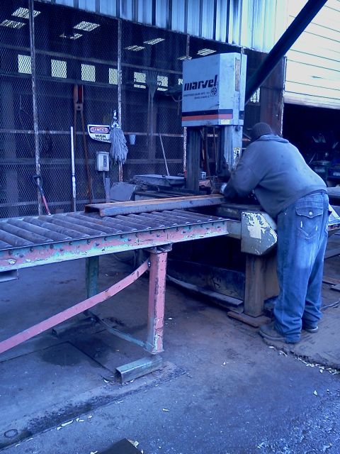 1989 Ford Bronco - Workshop scene with a man operating a Marvel metal cutting saw.
