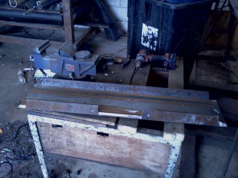 1989 Ford Bronco - Workshop scene with a vise, drill, and metal stock on a workbench.