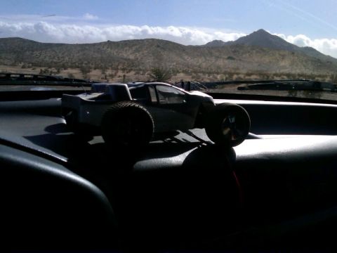 1986 Ford Bronco - A remote control truck sits on a dashboard with a desert landscape visible through the windshield.