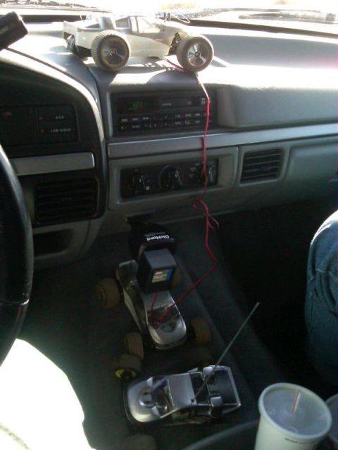 1986 Ford Bronco - Remote control cars are placed on the dashboard of a vehicle's interior.