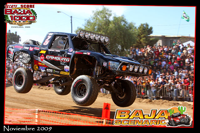 Black off-road truck mid-air, "CAMBURG" visible on side