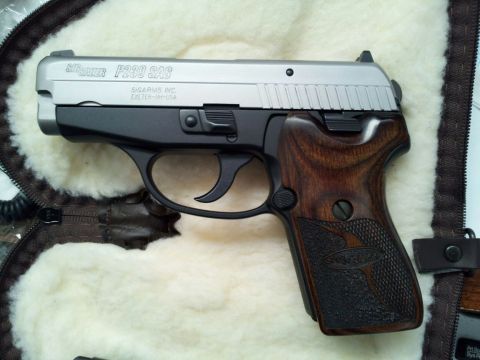 1996 Ford Bronco - A close-up view of a Sig Sauer P239 SAS pistol with distinctive wooden grip panels.