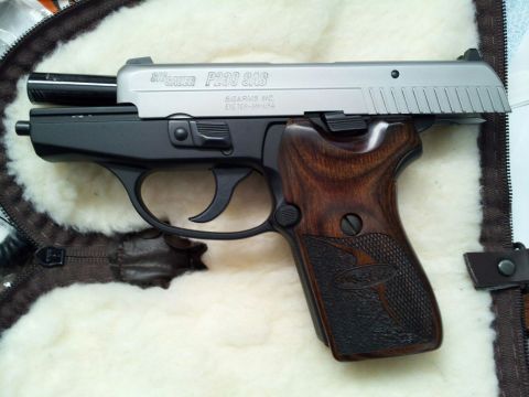 1996 Ford Bronco - A Sig Sauer P230 SAS pistol with distinctive wood grips is shown in a case.