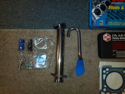 1993 Ford F-150 - A collection of automotive parts and tools are laid out on a carpeted surface.