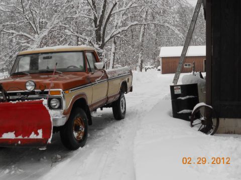1978 Ford Bronco - Ford F-Series pickup truck equipped with a snow plow sits in a snowy driveway.