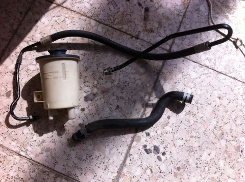 1998 Ford Crown Victoria - Power steering fluid reservoir and hoses shown laid out on a tiled surface.