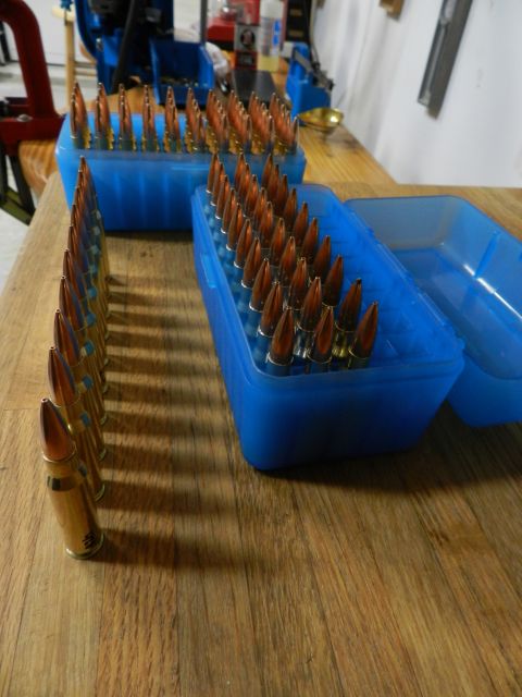 1996 Ford Bronco - Ammunition is organized in blue plastic boxes on a wooden table.