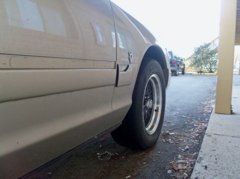 2000 Mercury Grand Marquis - A tan sedan is parked next to another vehicle, viewed from a low side angle.