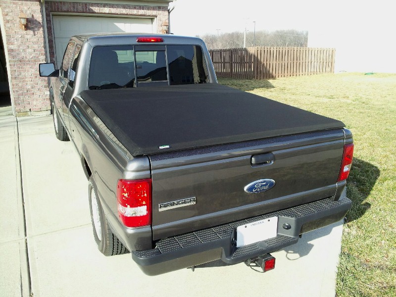 Dark gray Ford Ranger pickup truck rear view with black tonneau cover