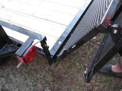 2005 Jeep Wrangler - Detail of a trailer ramp hinge mechanism, showing metal construction and wooden planks.