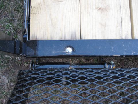 2005 Jeep Wrangler - This photo shows a close-up view of a trailer's ramp latch and part of its wooden deck.