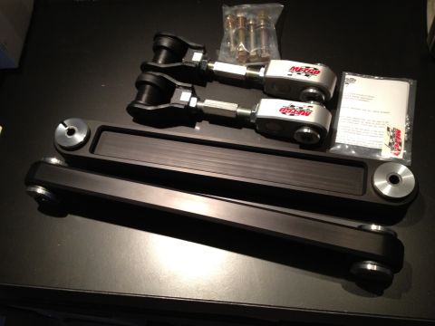 1992 Ford Crown Victoria - A set of Metco adjustable control arms and a bag of hardware are laid out on a dark surface.