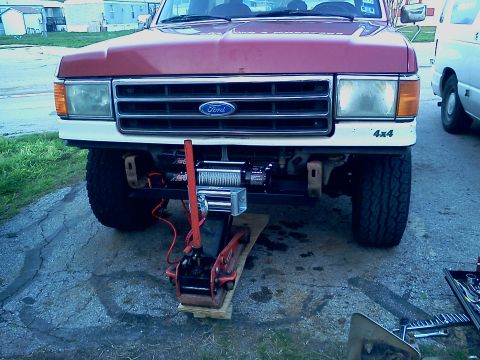 1989 Ford Bronco - Front view of a 1989 Ford Bronco showing a newly installed winch and a jack.