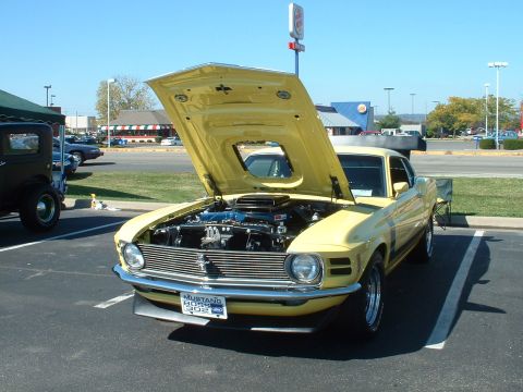 1995 Ford Crown Victoria - A yellow 1970 Ford Mustang Boss 302 is parked with its hood open, revealing the engine, in front of a Burger King.