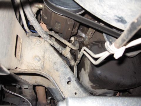 1995 Ford Bronco - Close-up view of engine components, including hoses and belts, within the chassis.