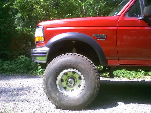 1996 Ford F-250 - Side view of a red 1996 Ford F-250 Heavy Duty truck with large tires.