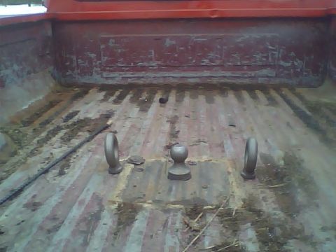 1987 Ford F-250 - The bed of a 1987 Ford F-250 pickup truck, showing a gooseneck hitch assembly and tie-down rings.
