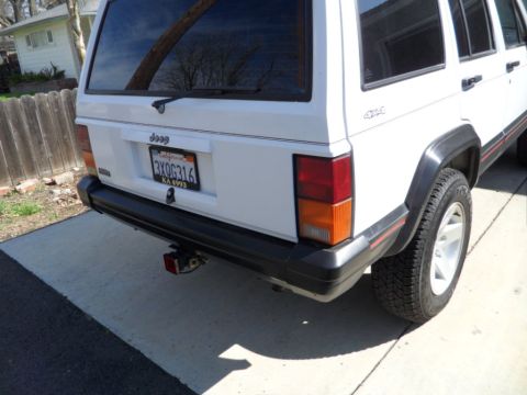 1994 Jeep Cherokee - Rear view of a white 1994 Jeep Cherokee, showing the tailgate and bumper.