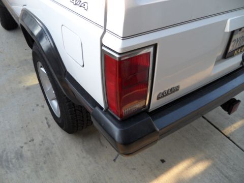 1994 Jeep Cherokee - Rear view of a white 1994 Jeep Cherokee showing the taillight and 4.0 Liter badging.