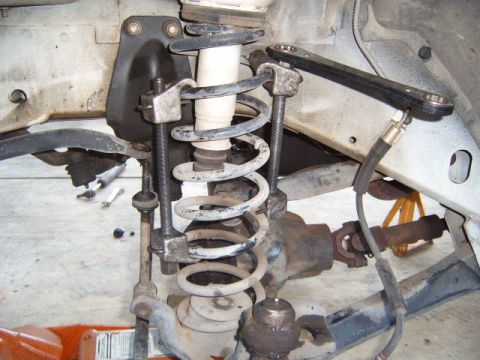 1994 Jeep Cherokee - Vehicle suspension work in progress with a spring compressor tool in place.