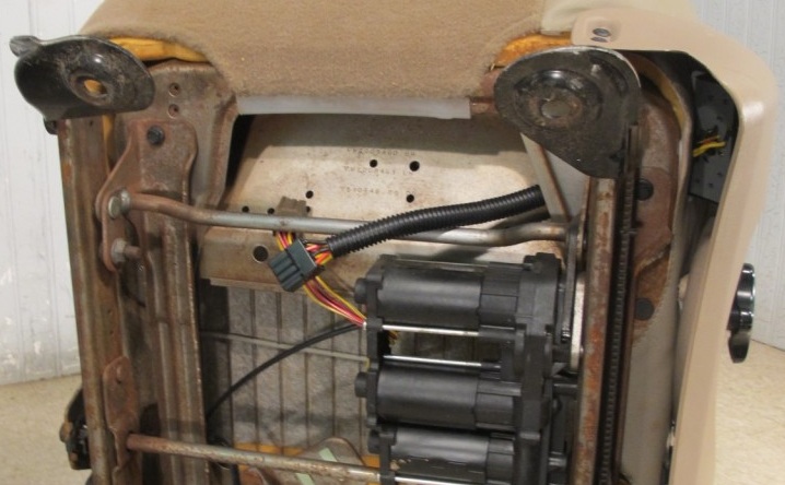Underside of a car seat showing the power seat motors and wiring