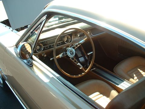 1995 Ford Crown Victoria - The interior of a classic Ford Mustang features a wood-grain steering wheel and two-tone seats.