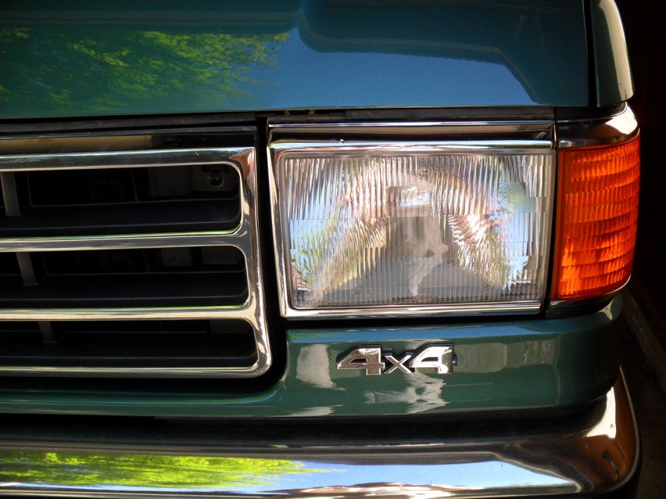 Green 4x4 SUV front with chrome grille and headlight