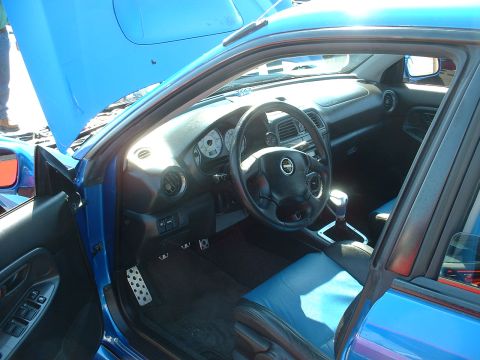 1995 Ford Crown Victoria - Interior view of a blue car with the hood open, showing the dashboard and seats.