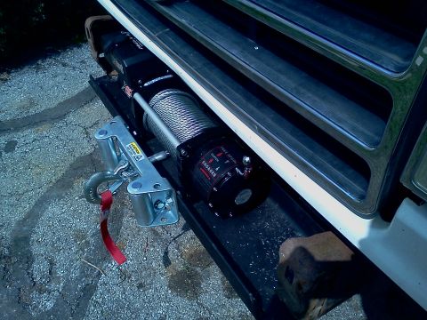 1989 Ford Bronco - A winch is mounted to the front of a vehicle, ready for towing or recovery operations.