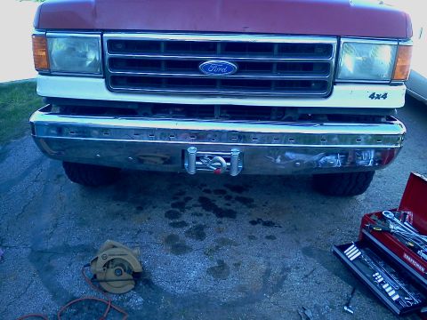 1989 Ford Bronco - Front view of a 1989 Ford Bronco, a chrome bumper with an integrated winch and a 4x4 decal on the fender.