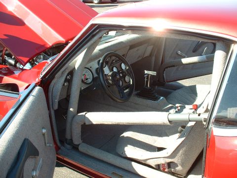 1995 Ford Crown Victoria - The interior of a modified vehicle features a roll cage, racing seats, and a custom steering wheel.