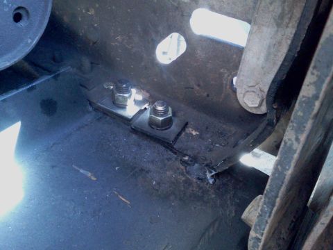 1989 Ford Bronco - Close-up view of the hardware used for a winch mount, showing bolts and metal brackets.