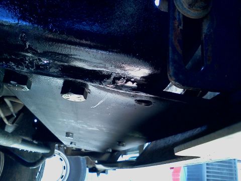 1989 Ford Bronco - This photo shows the underside of a vehicle, focusing on a bolted metal skid plate.