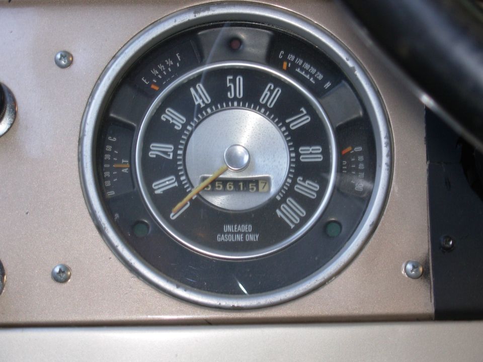 Vintage round speedometer and gauge cluster reading mileage