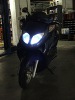 2008 Yamaha Zuma - A black scooter is shown from the front with its headlights on.