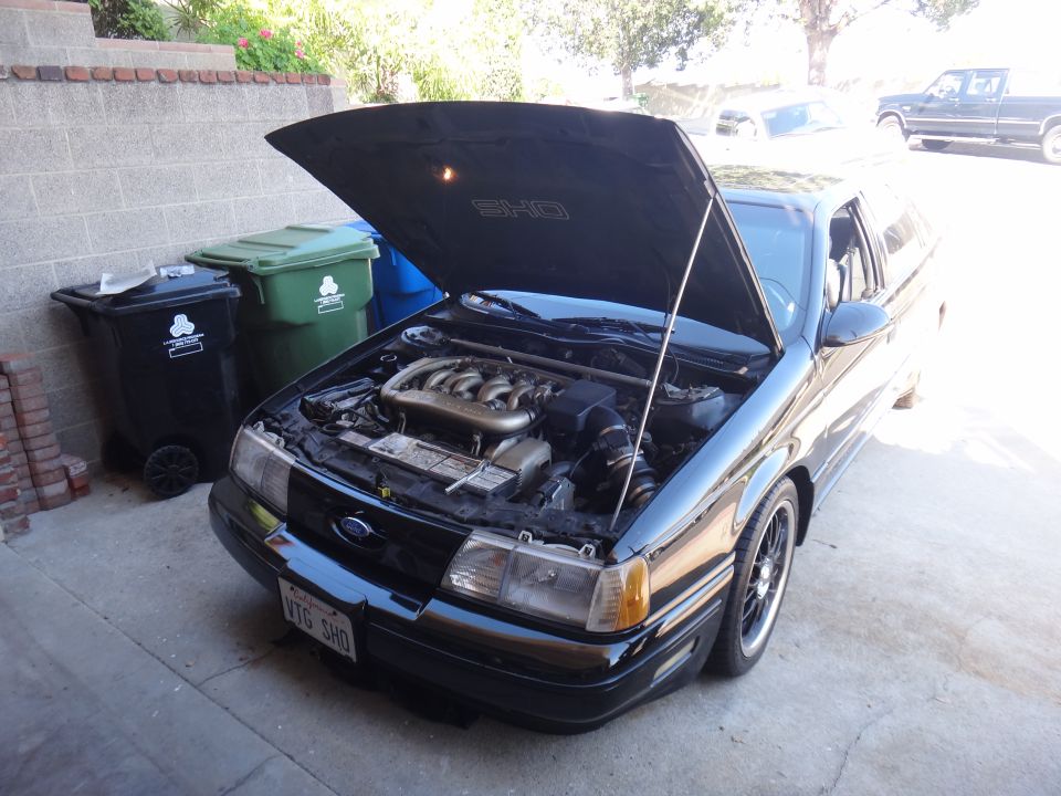 Black 1993 Ford Taurus SHO with hood open, showing the engine. License plate reads VTG SHO