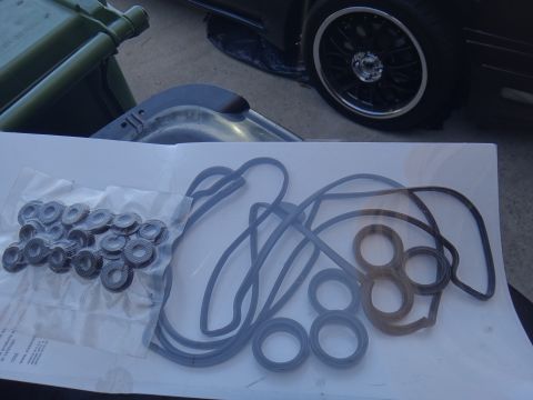 1993 Ford Taurus - A collection of engine gaskets is laid out on paper, with a green jerrycan and a car wheel visible.
