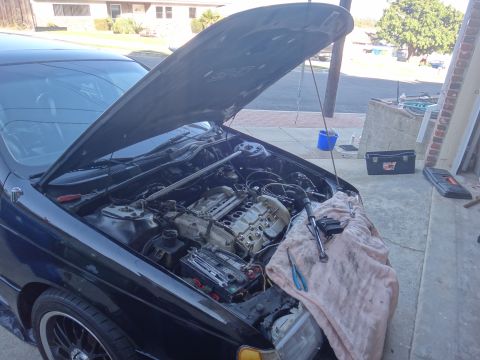 1993 Ford Taurus - Tools are laid out on a blanket next to the engine of a car with its hood open.