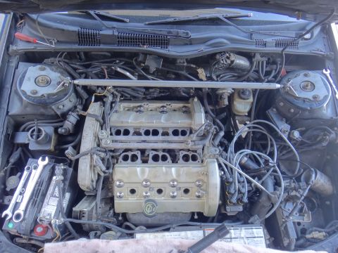 1993 Ford Taurus - The engine bay of a 1991 Ford Taurus shows a V6 engine with tools laid out on the battery.