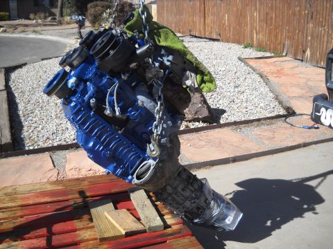 1992 Ford Explorer - A blue painted engine and transmission assembly is suspended by chains, ready for installation or transport.
