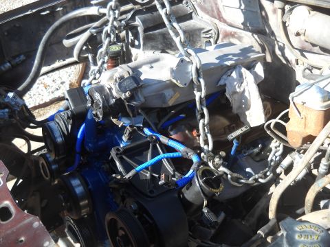 1992 Ford Explorer - Engine assembly with blue hoses and chains, suspended for removal or installation.