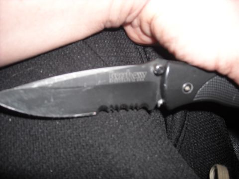 1979 Ford F-150 - A Kershaw folding knife is held in a hand, showing its partially serrated blade and textured handle.