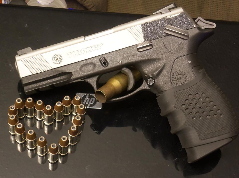 Taurus pistol with a heart shape made of bullets and a single bullet in the chamber