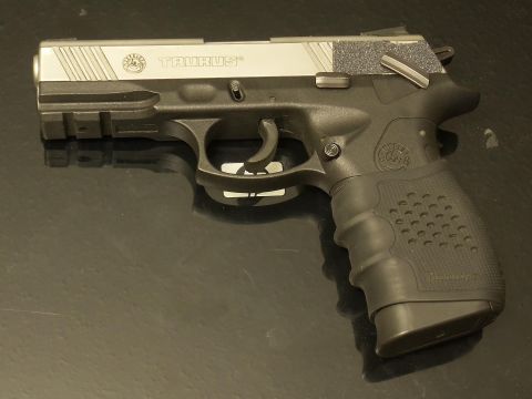 2000 Mercury Grand Marquis - A Taurus pistol is shown from the side, displaying its black and silver finish and textured grip.