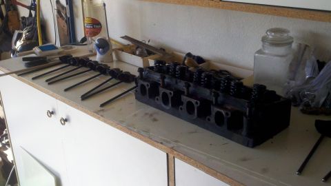 1978 Ford Bronco - Engine parts laid out on a workbench, likely for a rebuild or repair.