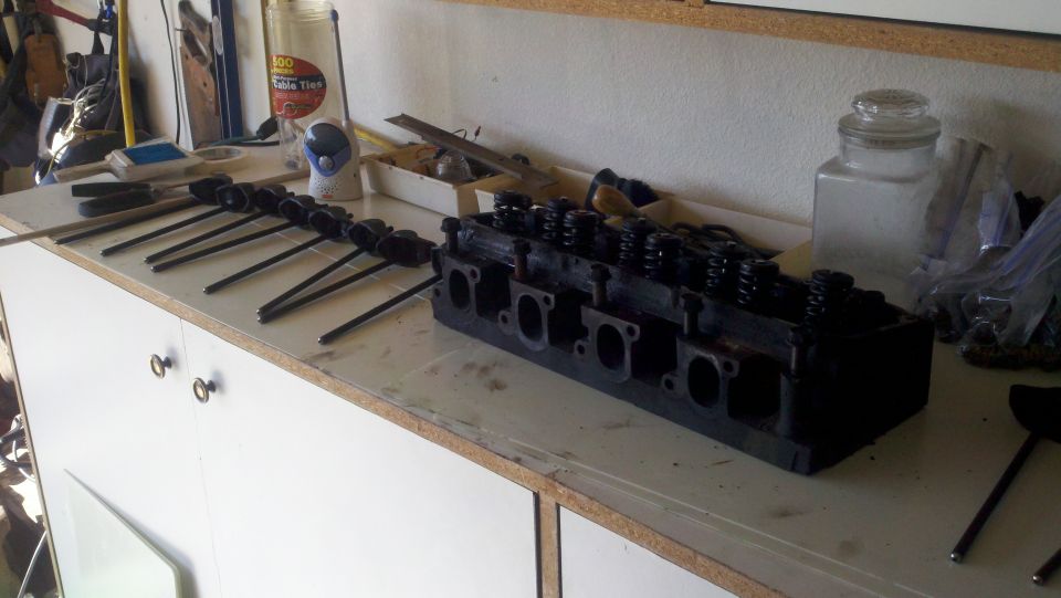 Engine cylinder head and pushrods on a workbench